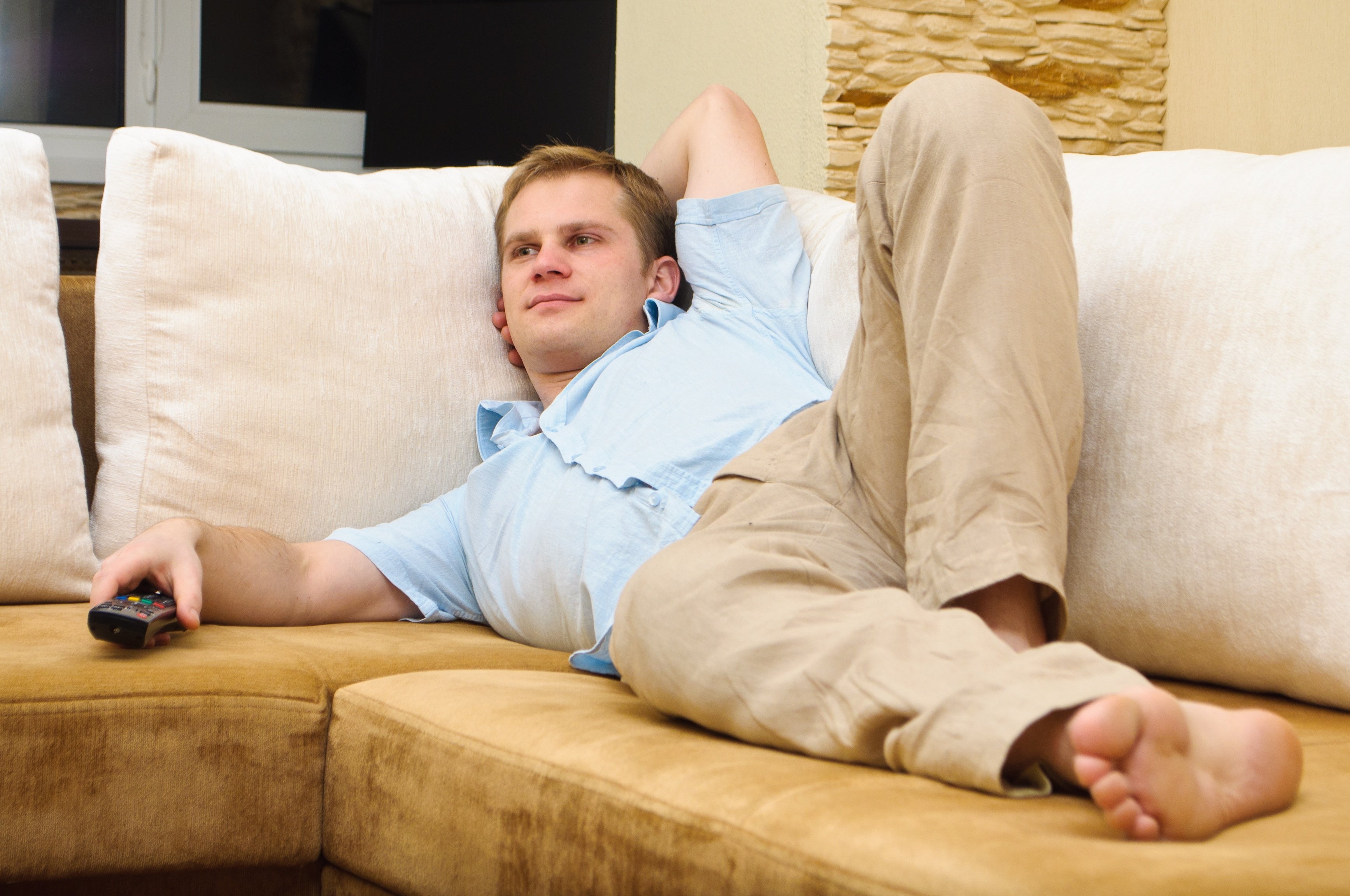 Где можно расслабиться. Лежит на диване. Человек лежит на диване. Человек отдыхает на диване. Мужчина на диване.