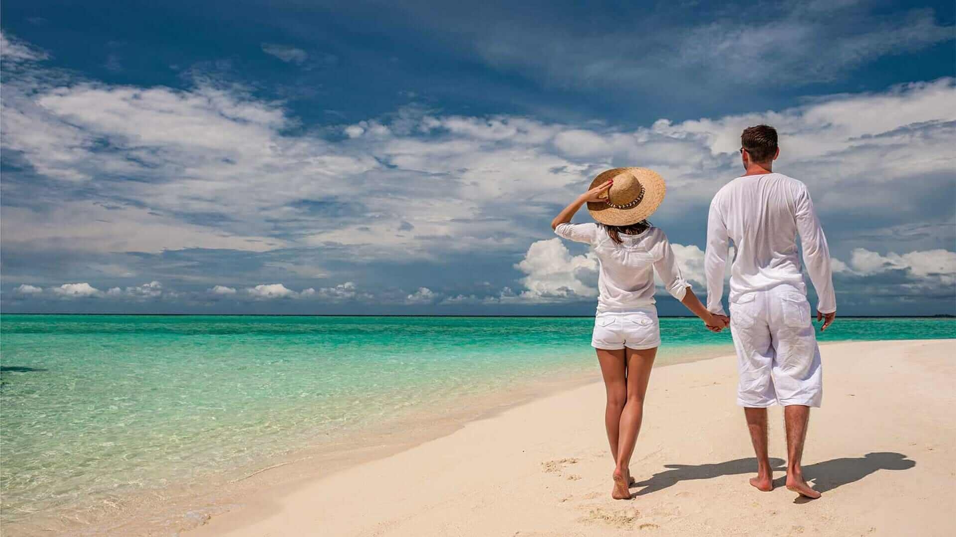 Отдых парень и девушка. Счастливая пара на Мальдивах. Семейная пара на пляже. Парочка на отдыхе. Влюбленная пара на отдыхе.