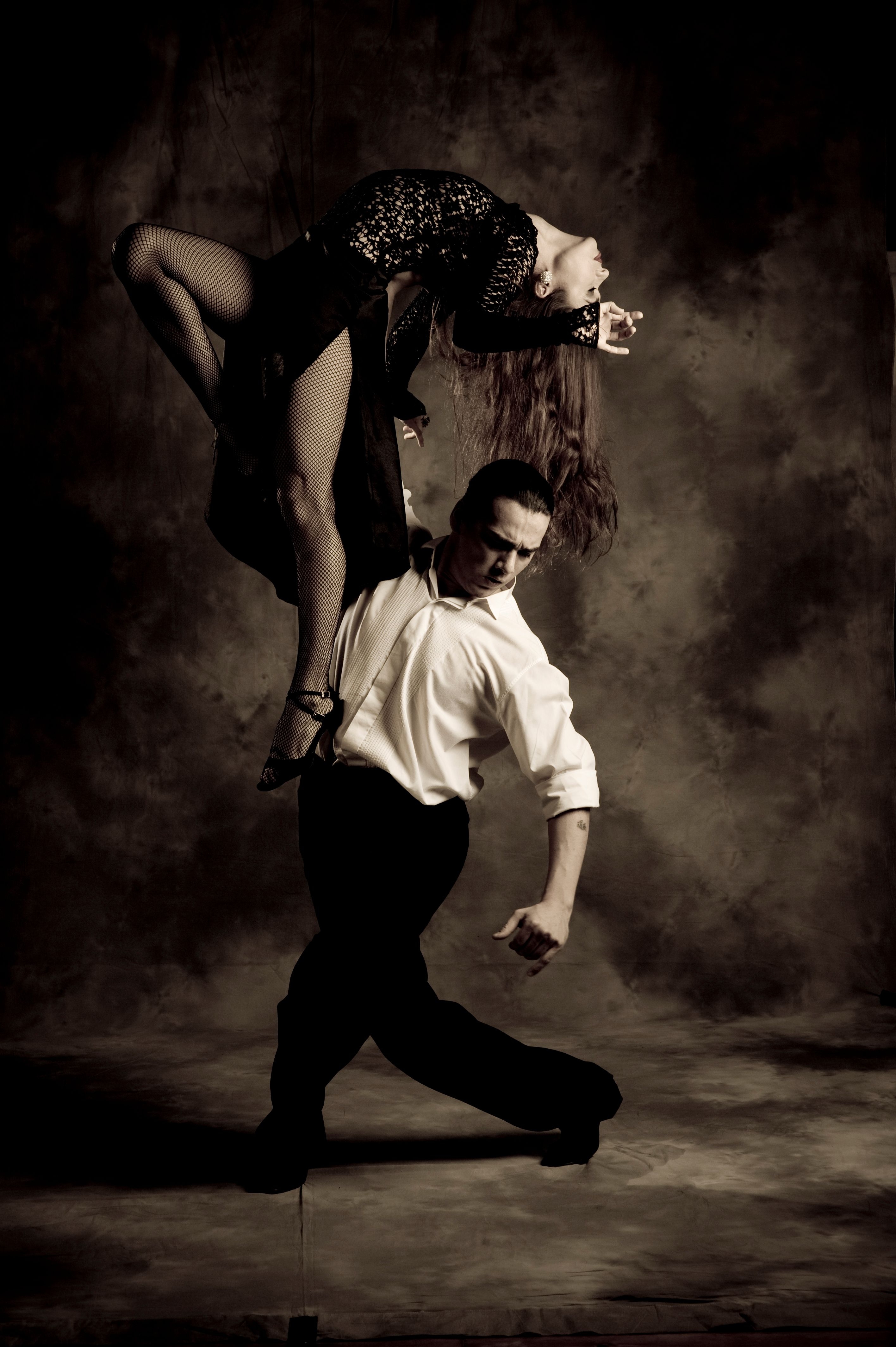 Красивый танец мужчины. Танец мужчины и женщины. Танго. Танго танец. Танцующая пара в темноте.